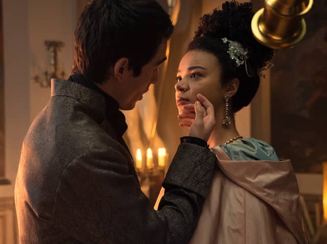 Corey Mylchreest as Young King George and India Amarteifio as Young Queen Charlotte in Queen Charlotte: A Bridgerton Story. He brushes her face as they turn away from his telescope (Credit: Liam Daniel/Netflix)