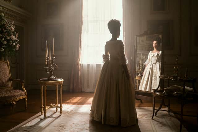 India Amarteifio as Young Queen Charlotte in Queen Charlotte: A Bridgerton Story, standing in front of the mirror as light pours in through a nearby window (Credit: Liam Daniel/Netflix)
