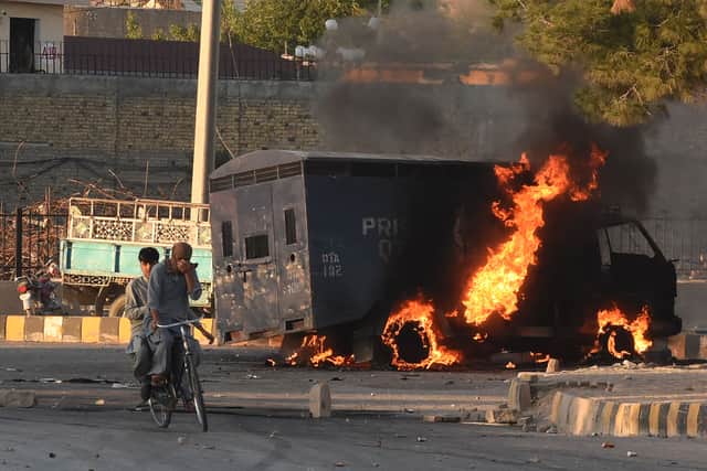 A police vehicle burns following a protest by Pakistan Tehreek-e-Insaf party activists and supporters of former Imran Khan against his arrest in May (Photo: BANARAS KHAN/AFP via Getty Images)