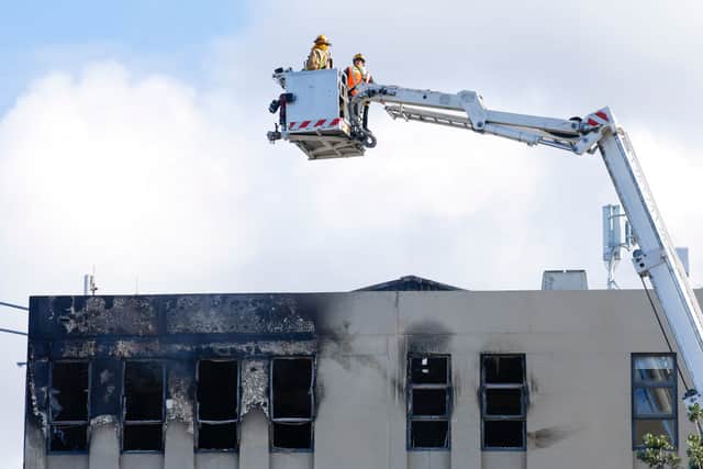 Firefighters survey the roof after the deadly fire at Loafers Lodge in Wellington (Photo by Hagen Hopkins/Getty Images)