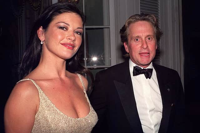 Catherine Zeta-Jones poses with Michael Douglas at the State Department in Washington, DC late 04 December 1999 following a dinner for the Kennedy Center Honorees. (Photo: NESHAN NALTCHAYAN/AFP via Getty Images)