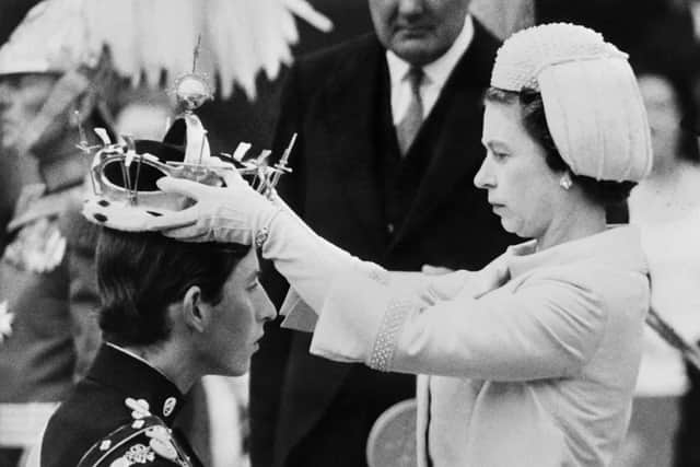 Queen Elizabeth II puts a crown on his son Prince Charles during his investiture as new Prince of Wales in Caernarfon on July 1, 1969. (Photo by CENTRAL PRESS / AFP) (Photo by -/CENTRAL PRESS/AFP via Getty Images)