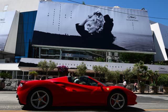 The official poster of the 76th Cannes Film Festival featuring a photograph of actress Catherine Deneuve on the facade of the Palais des Festivals in Cannes (Photo: CHRISTOPHE SIMON/AFP via Getty Images)