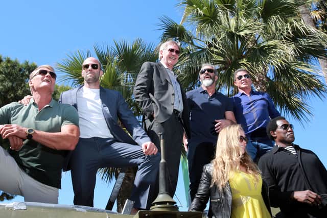 (From L) Swedish actor Dolph Lundgren, British actor Jason Statham, US actor Harrison Ford, Australian actor Mel Gibson, US actor Sylvester Stallone, US actress Ronda Rousey (bottom, L) and US actor Wesley Snipes (bottom R) pose on a tank as they arrive for a photocall for the film "The Expendables 3" at the 67th edition of the Cannes Film Festival in Cannes, southern France, on May 18, 2014.    AFP PHOTO / LOIC VENANCE / AFP / LOIC VENANCE        (Photo credit should read LOIC VENANCE/AFP via Getty Images)