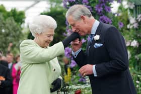 Queen Elizabeth II presents King Charles, then Prince Charles, Prince of Wales with the Royal Horticultural Society's Victoria Medal of Honour during a visit to the Chelsea Flower Show on May 18, 2009 in London. The Victoria Medal of Honour is the highest accolade that the Royal Horticultural Society can bestow. (Photo by Sang Tan/WPA Pool/Getty Images)