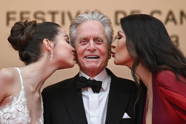 British actress Catherine Zeta-Jones (R) and her daughter Carys kiss US actor Michael Douglas on the cheek as they arrive for the opening ceremony and the screening of the film "Jeanne du Barry" during the 76th edition of the Cannes Film Festival in Cannes, southern France, on May 16, 2023. (Photo by LOIC VENANCE / AFP) (Photo by LOIC VENANCE/AFP via Getty Images)