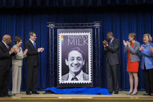 Deputy Postmaster General Ronald Stroman (3rd R) and Co-founder and President of the Harvey Milk Foundation Stuart Milk (3rd L) unveil the Harvey Milk Forever stamp during a ceremony in Old Executive Office Building in Washington, DC, May 22, 2014. (Photo credit : JIM WATSON/AFP via Getty Images)