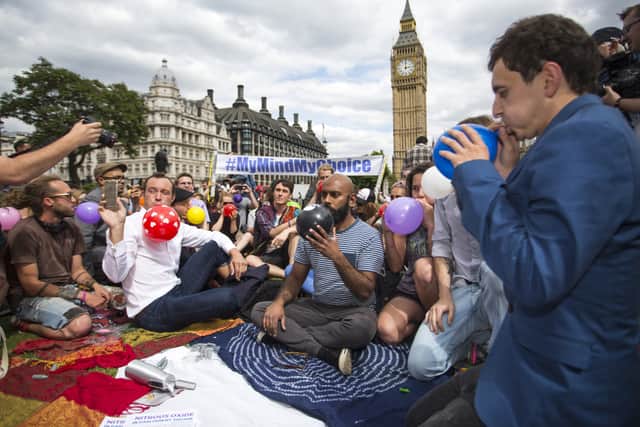 Protesters inhale laughing gas outside the Houses of Parliament in London, 2015 