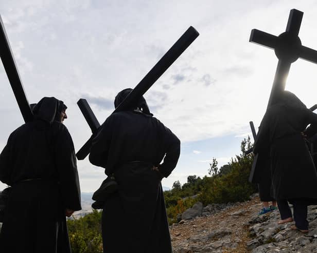 Penitents carry crosses during the "Romeria a la Trinidad" pilgrimage in the village of Lumbier on June 12, 2022. - The pilgrimage of Lumbier is a penitential celebration that takes place every year on Sunday of the Holy Trinity