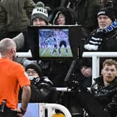 Referee Paul Tierney makes a VAR check in front of Newcastle fans