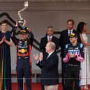 Max Verstappen lifts his trophy with Alonso and Ocon celebrating their second and third positions respectively