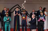 Max Verstappen lifts his trophy with Alonso and Ocon celebrating their second and third positions respectively