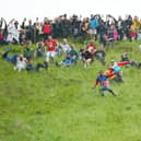 Contestants in the men’s downhill race chase the cheese down the hill in June 2022 at Cooper’s Hill in Gloucester, England. 