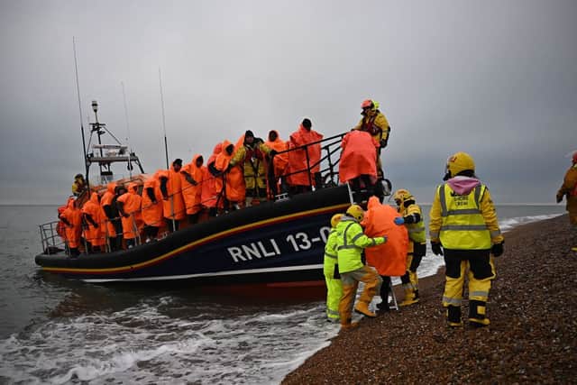 Migrants, picked up at sea attempting to cross the English Channel, are helped ashore from an Royal National Lifeboat Institution (RNLI) lifeboat, at Dungeness in Kent, on 9 December 2022. Credit: Getty Images