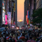 The sun sets in alignment with Manhattan streets running east-west, also known as Manhattanhenge, in New York on May 30, 2023 (Image: AFP via Getty Images)