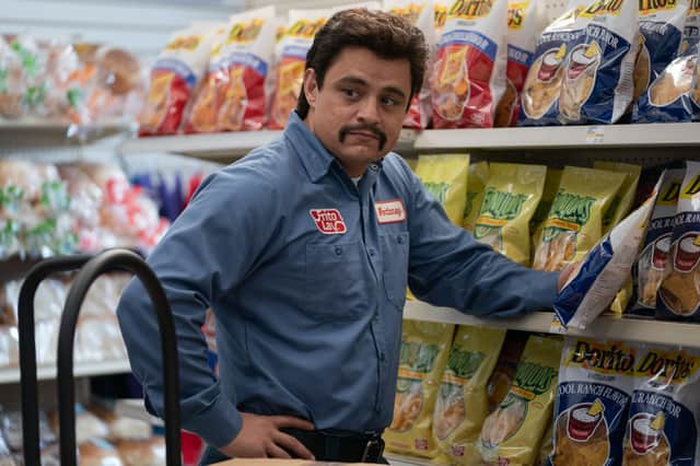 Jesse Garcia as Richard Montañez in Flamin' Hot, stocking supermarket shelves (Credit: Emily Aragones)