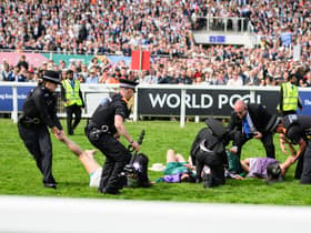Animal rebellion activist are arrested after running onto the racecourse, on day two of the Epsom Derby, on June 04, 2022 