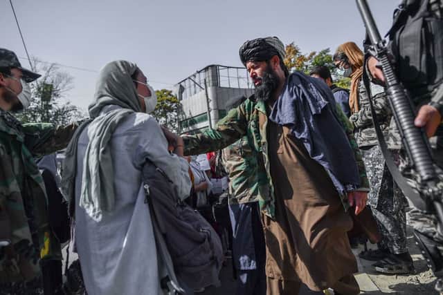 Taliban members stop women protesting for women’s rights in Kabul on October 21, 2021. (Photo by BULENT KILIC / AFP via Getty Images)