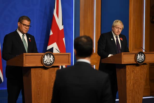 President for COP26 Alok Sharma (L) and former Prime Minister Boris Johnson speak during a press conference inside the Downing Street Briefing Room on November 14, 2021 in London, England. (Photo by Daniel Leal - WPA Pool/Getty Images)