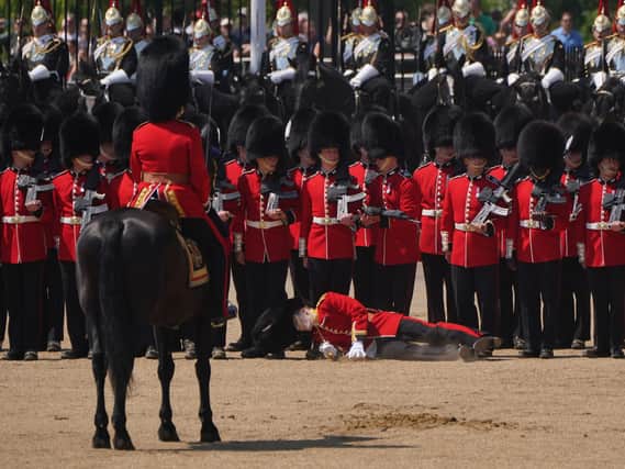 Image 7 of 8 in a sequence showing a member of the military fainting due to the heat during the Colonel's Review, for Trooping the Colour, at Horse Guards Parade in London, ahead of the King's Birthday Parade on June 17.