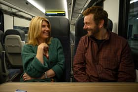 Sharon Horgan as Nicci and Michael Sheen as Andrew in Best Interests, sat together on the train (Credit: BBC/Chapter One/Samuel Dore)