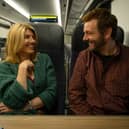 Sharon Horgan as Nicci and Michael Sheen as Andrew in Best Interests, sat together on the train (Credit: BBC/Chapter One/Samuel Dore)