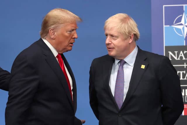 Then US President Donald Trump and then British Prime Minister Boris Johnson onstage during the annual NATO heads of government summit on December 4, 2019 in Watford, England.  (Photo by Steve Parsons-WPA Pool/Getty Images)