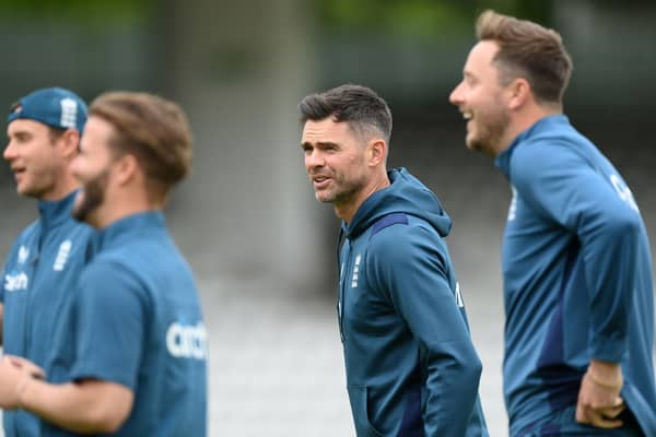 James Anderson looks on with Ollie Robinson (R) and Stuart Broad (far left)