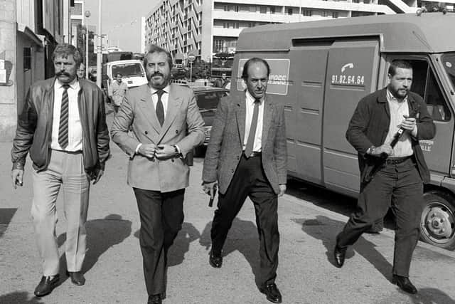 Italian Judge Giovanni Falcone (2nd-L), surrounded by armed bodyguards, arrives 21 October 1986 in Marseille to meet his French counterparts in charge to investigate the Mafia "Pizza Connection" criminal plot. (Credit: GERARD FOUET/AFP via Getty Images)