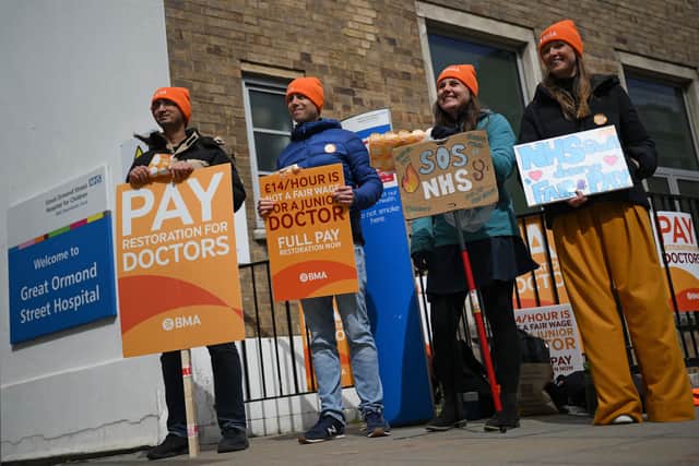 People hold placards on a picket line outside Great Ormond Street Children's Hospital in London on April 12, 2023, on the second day of a strike by junior doctors.(Photo by DANIEL LEAL/AFP via Getty Images)