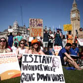 Demonstrators hold up placards as they take part in a protest by so-called 'junior doctors', physicians who are not senior specialists but who may have years of experience, in Parliament Square in central London, on June 16, 2023, during their on-going dispute with the government over over pay and working conditions. (Photo by HENRY NICHOLLS / AFP) (Photo by HENRY NICHOLLS/AFP via Getty Images)