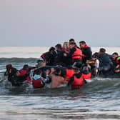 About fourty migrants, fom various origins, board an inflatable boat before they attempt to cross the Channel illegally to Britain, near the northern French city of Gravelines on July 11, 2022. (Photo by Denis Charlet / AFP) (Photo by DENIS CHARLET/AFP via Getty Images)