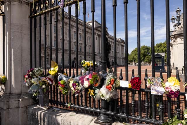 Members of the public lay flowers outside Buckingham Palace following the death of Queen Elizabeth II on September 12, 2022 in London, England.  (Photo by Dan Kitwood/Getty Images)