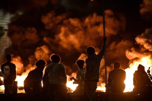 People look at burning tyres blocking a street in Bordeaux. Picture: PHILIPPE LOPEZ/AFP via Getty Images