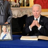 US President Joe Biden (R) signs a book of condolence at Lancaster House in London on September 18, 2022 following the death of Queen Elizabeth II on September 8. - Britain was gearing up Sunday for the momentous state funeral of Queen Elizabeth II as King Charles III prepared to host world leaders and as mourners queued for the final 24 hours left to view her coffin, lying in state in Westminster Hall at the Palace of Westminster. (Photo by Jonathan HORDLE / POOL / AFP) (Photo by JONATHAN HORDLE/POOL/AFP via Getty Images)