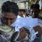 Victor Hugo Sosa, Mayor of San Pedro Huamelula, kisses a caiman before marrying her in San Pedro Huamelula, Oaxaca state, Mexico on June 30, 2023. (Photo by RUSVEL RASGADO/AFP via Getty Images)