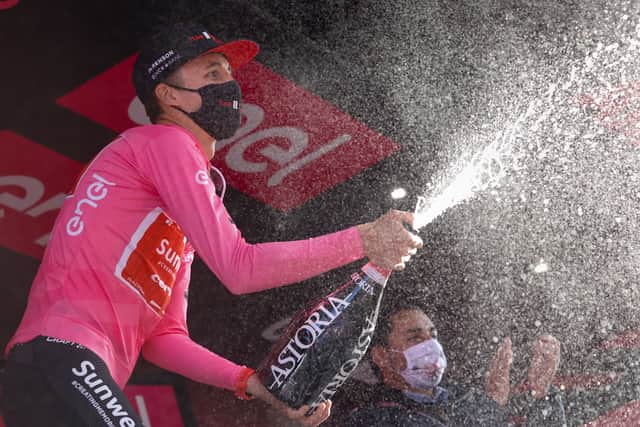 Team Sunweb rider Australia's Jai Hindley wearing the overall leader's pink jersey celebrates with champagne on the podium the 20th stage of the Giro d'Italia 2020 cycling race, a 198-kilometer route between Alba and Sestriere on October 24, 2020. (Photo by Luca Bettini / AFP) 