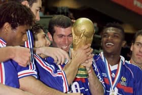 French players Bernard Diomede, Robert Pires, Bixente Lizarazu, Zinedine Zidane, Marcel Desailly and Laurent Blanc celebrate with the 1998 FIFA Trophy late 12 July at the Stade de France (Photo credit should read GABRIEL BOUYS/AFP via Getty Images)