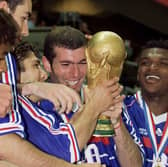 French players Bernard Diomede, Robert Pires, Bixente Lizarazu, Zinedine Zidane, Marcel Desailly and Laurent Blanc celebrate with the 1998 FIFA Trophy late 12 July at the Stade de France (Photo credit should read GABRIEL BOUYS/AFP via Getty Images)