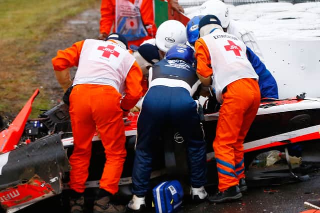 Jules Bianchi of France and Marussia receives urgent medical treatment after crashing