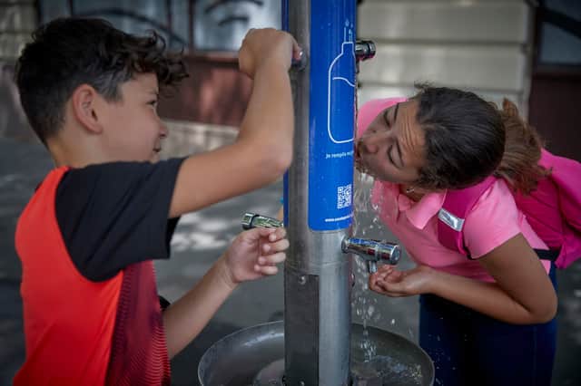 Children drink from a water fountain in France during heatwave