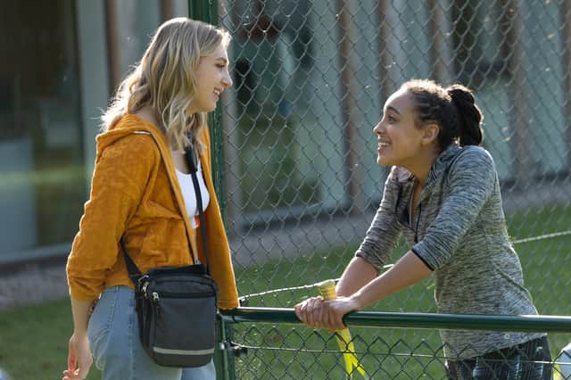 Ella Lily Hyland as Justine Pierce and Harmony Rose Bremner as Renee Okoye in Fifteen-Love, talking over a fence (Credit: Sally Mais/Amazon Prime Studios)