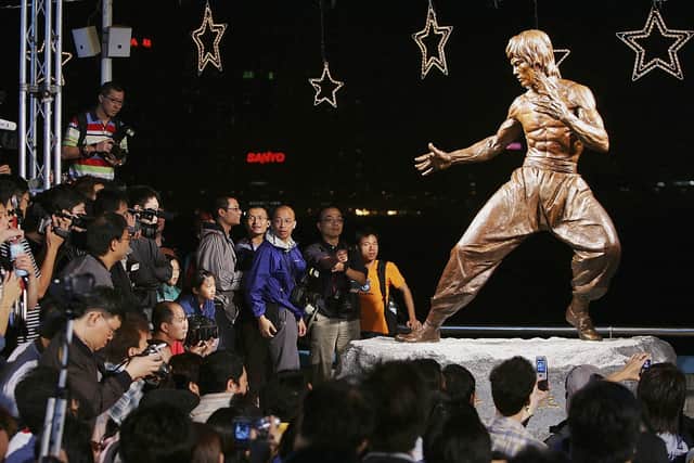 Crowds gather around the bronze statue of late martial arts legend and movie superstar Bruce Lee after a unveiling ceremony at Avenue of Stars on November 23, 2005 in Hong Kong. The ceremony is part of Bruce Lee Festival to celebrate the star's 65th birthday. Bruce was died in 1973 at the age of 32.  (Photo by MN Chan/Getty Images)