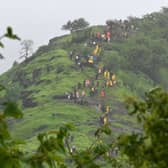Rescue workers and villagers are seen on the hillock leading up to the site of the landslide at Irshalwadi village in Raigad district of India's Maharashtra state on July 20, 2023 (Photo by INDRANIL MUKHERJEE/AFP via Getty Images)