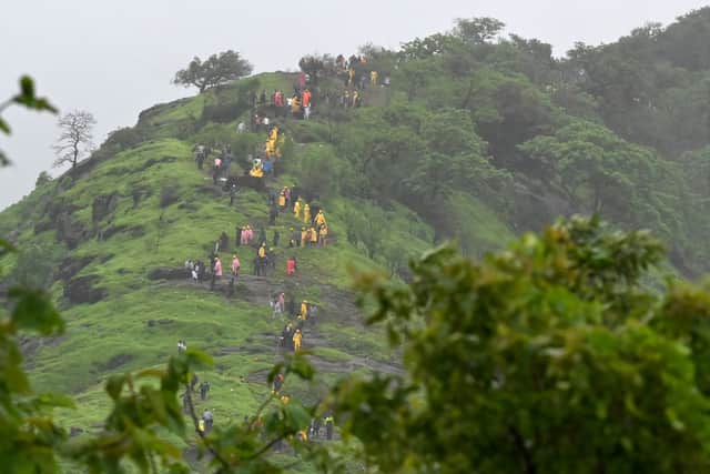 Rescue workers and villagers are seen on the hillock leading up to the site of the landslide at Irshalwadi village in Raigad district of India's Maharashtra state on July 20, 2023 (Photo by INDRANIL MUKHERJEE/AFP via Getty Images)