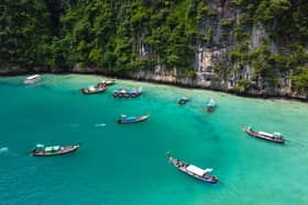 This aerial picture taken on November 26, 2021 shows tourists in longtail boats in Phi Phi Leh. (Photo by LILLIAN SUWANRUMPHA/AFP via Getty Images)