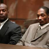 Rapper Snoop Dogg, right, real name is Calvin Broadus, and his bodyguard McKinley Lee await the reading of a verdict in his murder trial 20 February 1996. POO/AFP via Getty Images)