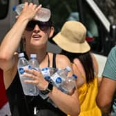 A woman cools off with cold bottles of water in Athens on July 20, as Greece dealt with a new major heatwave (Photo by LOUISA GOULIAMAKI/AFP via Getty Images)