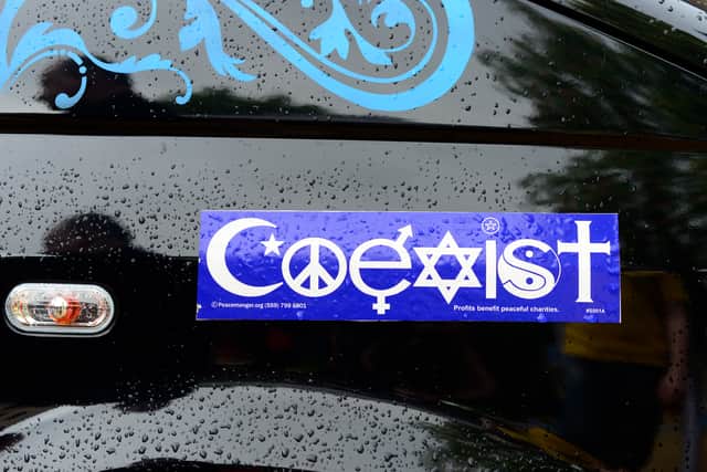 A sticker featuring various religious symbols bedecks a Volkswagen Multivan (JOHN MACDOUGALL/AFP via Getty Images)
