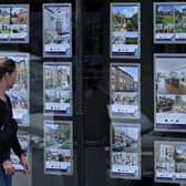 A pedestrians looks at residential properties displayed for sale in the window of an estate agents' in Windsor, west of London, on July 29, 2023. (Photo by JUSTIN TALLIS/AFP via Getty Images)
